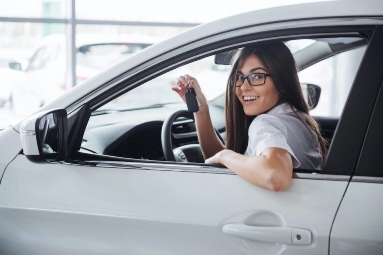 image of woman holding keys in her new car